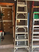 Full view of the 8-foot aluminum stepladder and aluminum step stool leaning against a wall.