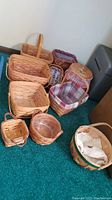 Overview of all ten baskets arranged on carpet, showing a variety of sizes, shapes, and some with liners.
