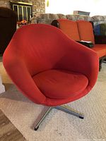 Front and side view of the red Mid Century Modern swivel chair showing curved back, seat and metal base