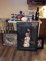 Full view of the lot showing framed posters of Cal Ripken Jr. and Joe Flacco, Memorial Stadium photograph, signed football, bobbleheads, bottles, glasses, and other Orioles memorabilia.