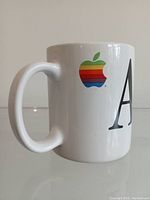 Front view showing rainbow Apple logo near handle and beginning of the word 'Apple' in large black font