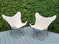 Two folding butterfly chairs on deck with canvas slings and steel frames
