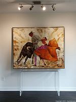 Full view of framed painting on wall above clear acrylic console