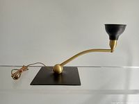 Full view of vintage MG Wheeler desk lamp with brass arm, black square base, and black shade missing upper portion.