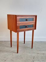 Front angled view showing two drawers and tapered legs
