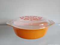 Vintage Pyrex casserole dish with yellow bottom and floral Friendship pattern on lid.
