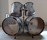 Front view showing both 24" bass drums with mounted 13" and 14" rack toms on central stand
