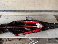 Top view of Atomic ski poles and carrying case zipped closed on a white table.