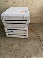 Four stacked Nintendo Wii consoles showing the front side with disc slots and buttons.