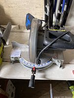 Side view of the Delta radial arm saw showing the blade guard, handle and angle markings on the base.