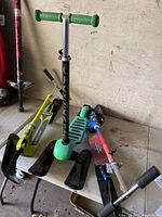 Three snow scooters placed on a white table, showing colorful skis and handles for snow gliding.