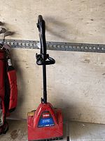 Photo of the red Toro Power Shovel electric snow shovel with black handle, showing front and handle details