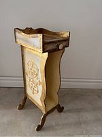 Side view of Florentine vintage telephone stand showing curved legs with claw feet and decorative floral motif on the side panel.