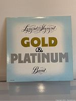 Front cover showing Lynyrd Skynyrd Gold & Platinum album title in gold and silver lettering on pale blue and white background.