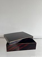 Open view showing the interior and lid of the vintage lacquer box, highlighting size and condition.