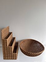 Photo of stepped wicker storage holder with three compartments alongside a round wicker bowl basket, showing their size relative to each other.