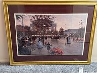 Front view of the framed signed print titled 'Bustling Boulevard' showing the detailed boulevard scene with people and street lamps in evening light, including the gold frame and dark matting.