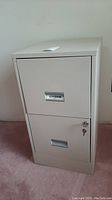 Closed view of the beige two drawer SteelWorks metal file cabinet with key in lock.