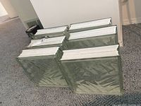 Six clear glass blocks placed on carpet, showing their edges and dimensions.