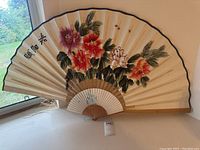 Large hand fan with painted pink and red flowers, green leaves, and Asian characters.