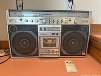 Front view of Toshiba RT-8980SM stereo radio cassette recorder showing speakers, tuning dial, and control panel.