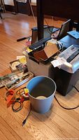 Wide view of lot showing Dynex shredder next to gray waste can, orange mouse, cords, packing tape, and storage basket in the plastic file box.