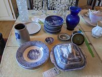 Photo showing entire lot with Royal Staffordshire covered dish, bowls, Wedgwood plates, cobalt blue vase, and pottery pitcher.