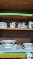 Photo showing Limoges teacups, saucers, and other smaller Kongo china pieces displayed on shelving.