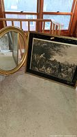 Both oval mirror and framed print leaning against wall near window, showing full items and condition.