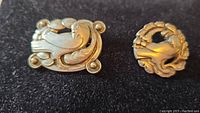 Both sterling silver brooches displayed together on black background
