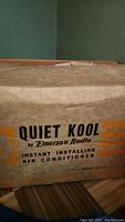Closed original cardboard box labeled Quiet Kool by Emerson Radio Instant Installing Air Conditioner.