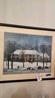 Framed winter scene print displayed on wall showing full artwork, frame, and matting.