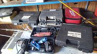 Overview of multiple tool cases including drill, rotary tools, and nailer stored on a shelf for inventory and identification.