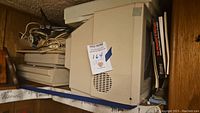 Side view of vintage beige Commodore 1084S CRT monitor with label and cords on top showing vintage condition.