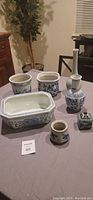 Overview of six ceramic items arranged on a table, showcasing variety in shapes and blue and white decorated surfaces