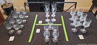 Top view of 19 assorted Longchamp Cristal D'Arques crystal wine glasses arranged on a table grouped by style/size.