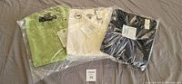 Three Talbots womens sequin cardigan sweaters in plastic packaging, colors green, white, and dark blue, tags attached, size 2X.