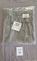 Two photos of each pair of Talbots stretch joggers packaged separately in clear plastic bags, folded, gray color, size 3X tags visible.