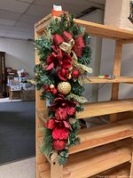 Full view of the 36-inch Christmas swag hanging on a wooden shelf, showing the overall size and decorated foliage.