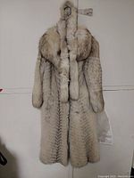 Coat on hanger front view showing overall silhouette and pattern