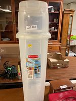 Front view of Rubbermaid Wrap'n Craft tall clear plastic gift wrap storage box with lid, showing label and lot number.