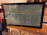 Full view of Samsung 43 inch flat screen TV standing on a wooden surface with a visible Samsung logo.