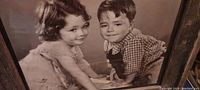 Close-up of the black and white photo showing Spanky and Darla, two children from The Little Rascals, in a rustic barn wood frame.