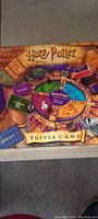 Top-down view of Harry Potter Sorcerer's Stone trivia game board with colorful sections and trivia categories, surrounded by trivia cards.