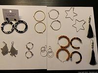 Full view of the lot showing all 10 pairs of earrings arranged on two surfaces.