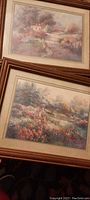 Photo showing both framed art prints together, both featuring landscape scenes with wooden frames under glass.