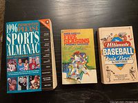 Three sports and baseball books laid flat showing front covers: 1996 Information Please Sports Almanac, Five Seasons: A Baseball Companion, and The Ultimate Baseball Quiz Book.