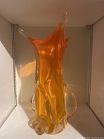 Front angle of the abstract orange glass vase with organic flowing shape