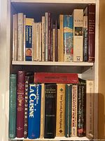 Shelf with wine and spirits related books and general cooking books including Escoffier Cook Book, Michelin Guide 1975, La Cuisine by Raymond Oliver
