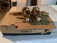 Photo of the faucet set including hot and cold handles on top of the original Riobel box.